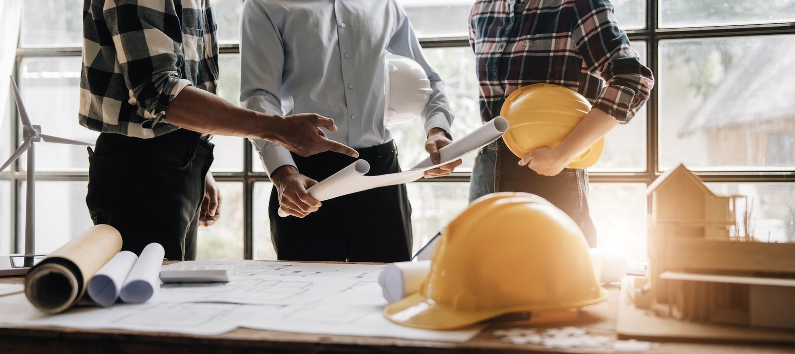 Civil engineer teams meeting working together wear worker helmets hardhat on construction site in